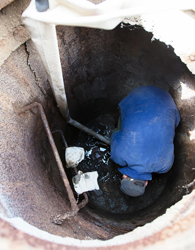 Arbeiter reinigt einen Kanal bei einer Kanalreinigung in München.