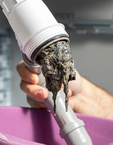 Verstopftes Rohr mit Ablagerungen, das bei einer Rohrreinigung in München gereinigt wird.